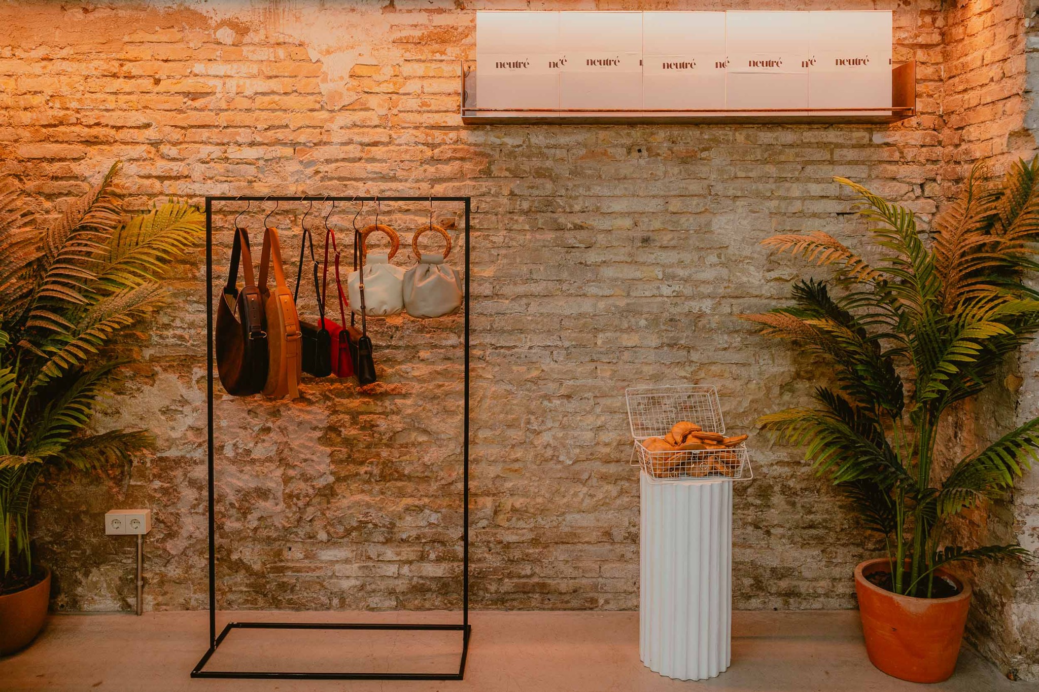 Montaje del pop-up de Neutré con bolsos, plantas y cesta de monederos croissant