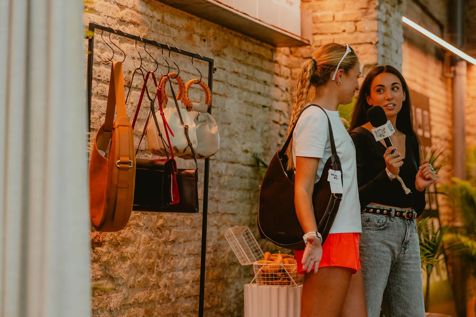 Dos asistentes junto a la exposición de bolsos de Neutré