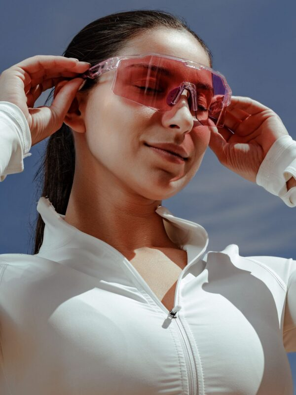 Una mujer ajusta sus gafas rosas de Forty One en el exterior