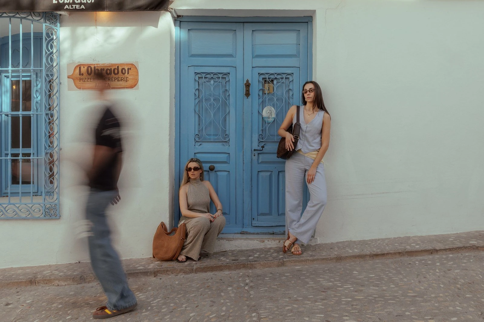 Dos mujeres con bolsos de Neutré junto a una puerta azul