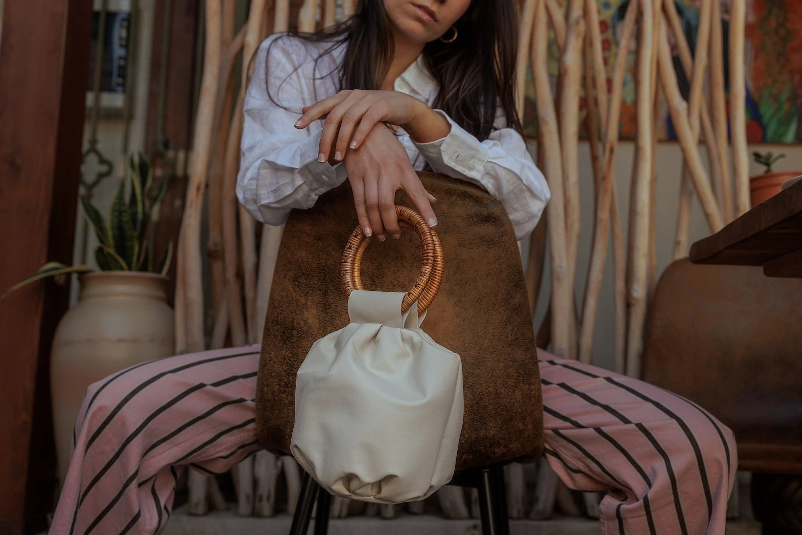 Bolso de Neutré junto a una mujer sentada en una puerta